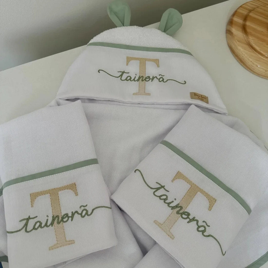 Toalha com capuz de orelhinhas e fraldas com a inicial e o nome bordados