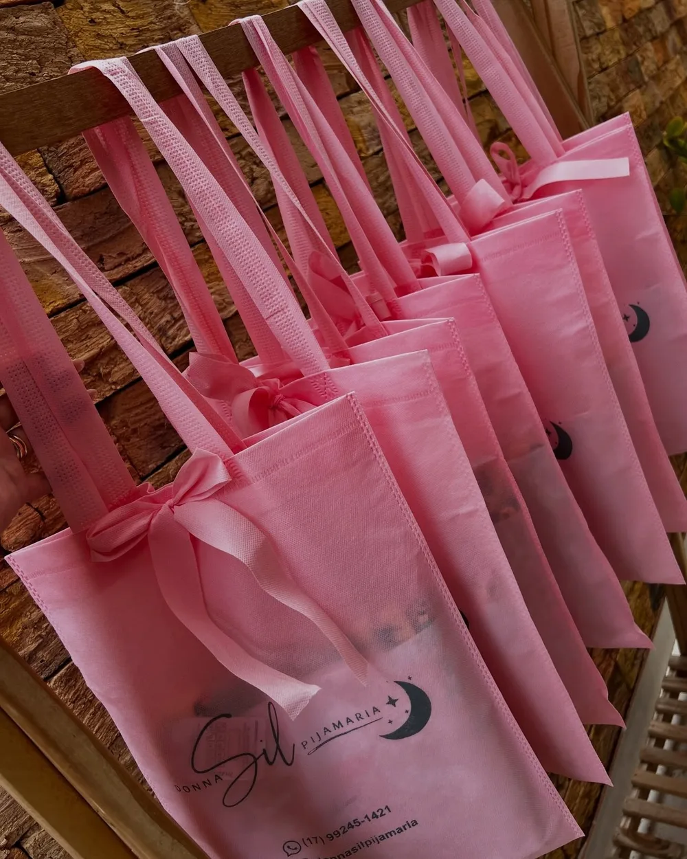 Ecobags rosa da Donna Sil com laço de fita, penduradas