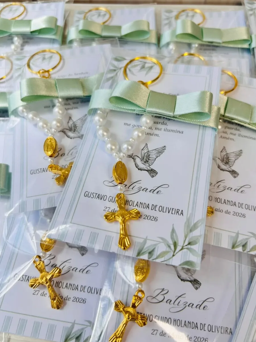 Lembrancinhas de batizado da Lumiar, com terço de pérolas, cruz dourada e cartão com o nome do bebê