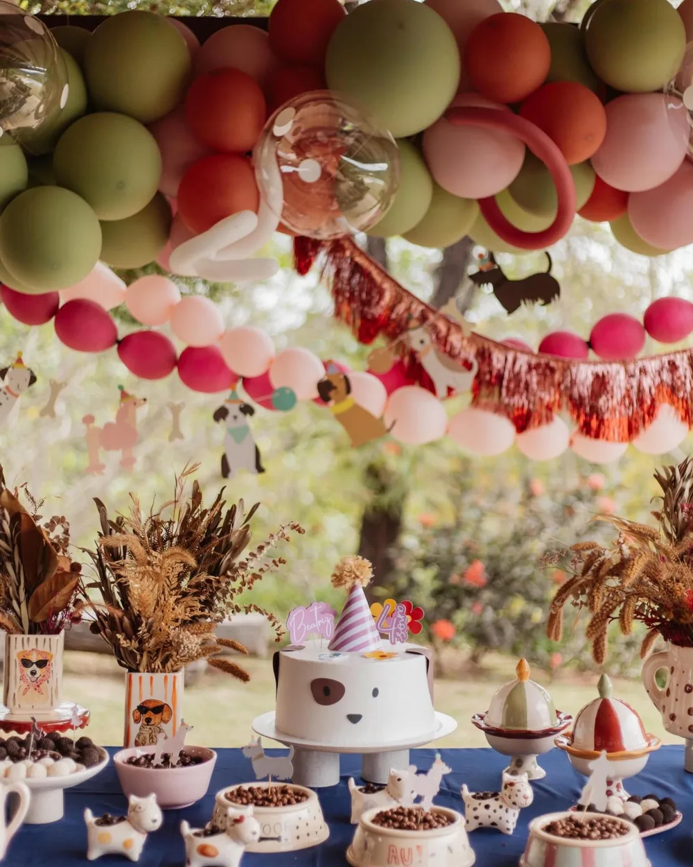 Mesa de festa de aniversário com tema de cachorrinho e as peças de cerâmica pintadas à mão