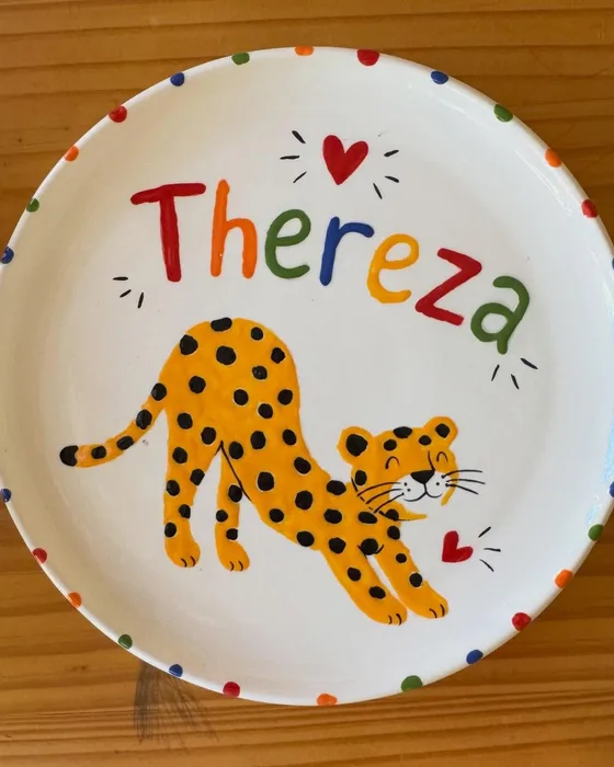 Prato infantil com o nome Thereza e uma oncinha pintada à mão